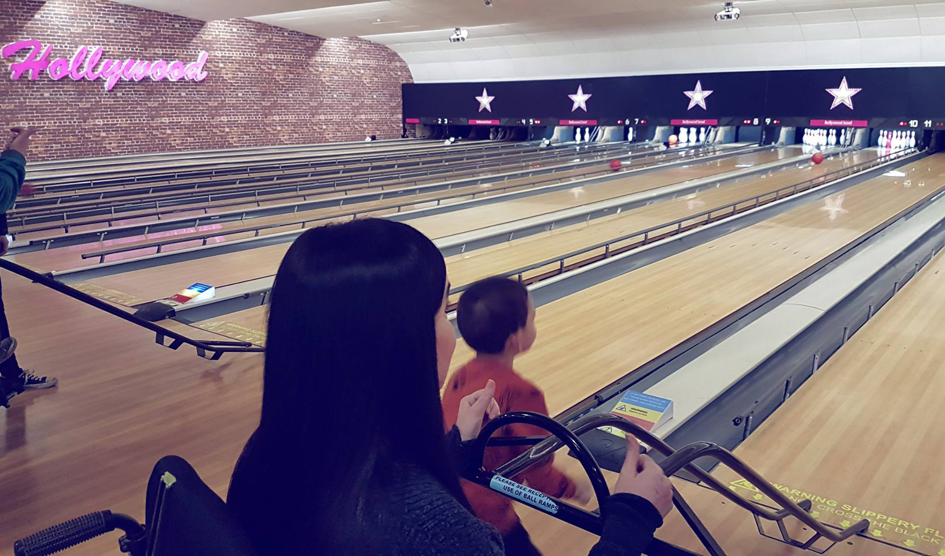 Emma of Simply Emma at ten pin bowling with her nephew using a ramp for the bowling balls.
