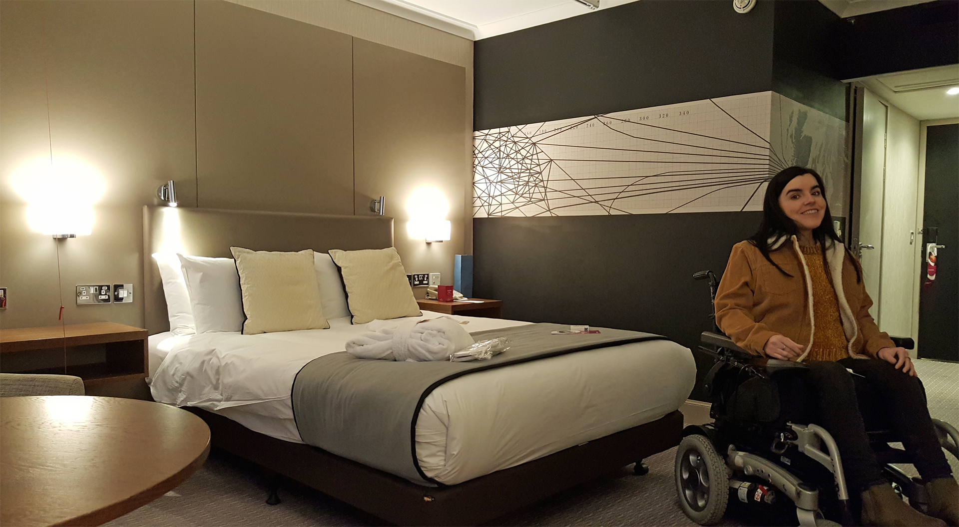 Emma of Simply Emma sitting in her wheelchair in her Crowne Plaza Glasgow hotel room.