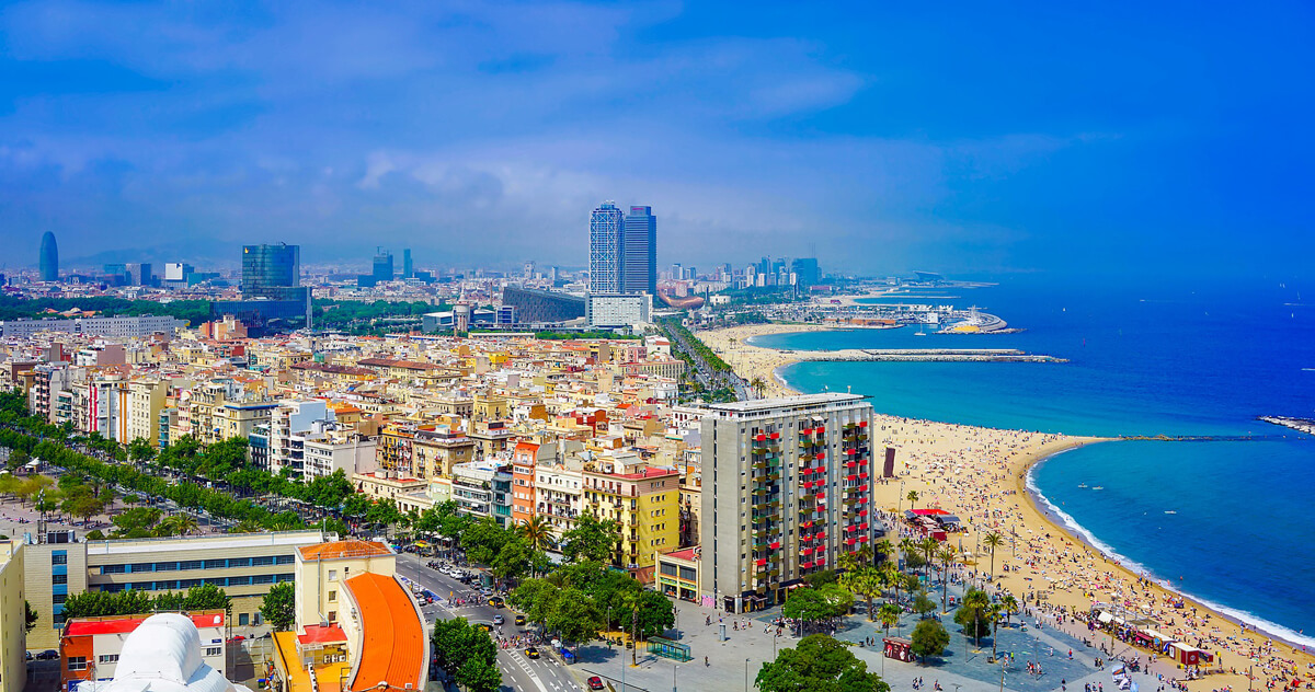 5 of the Safest Cities to Navigate With a Disability: A view of Barcelona city from up high overlooking the streets and beach.