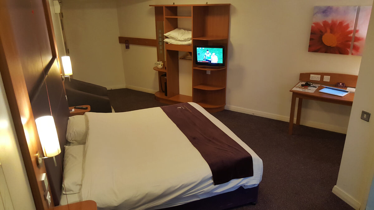 Image of our accessible room showing the bed, desk and wardrobe.