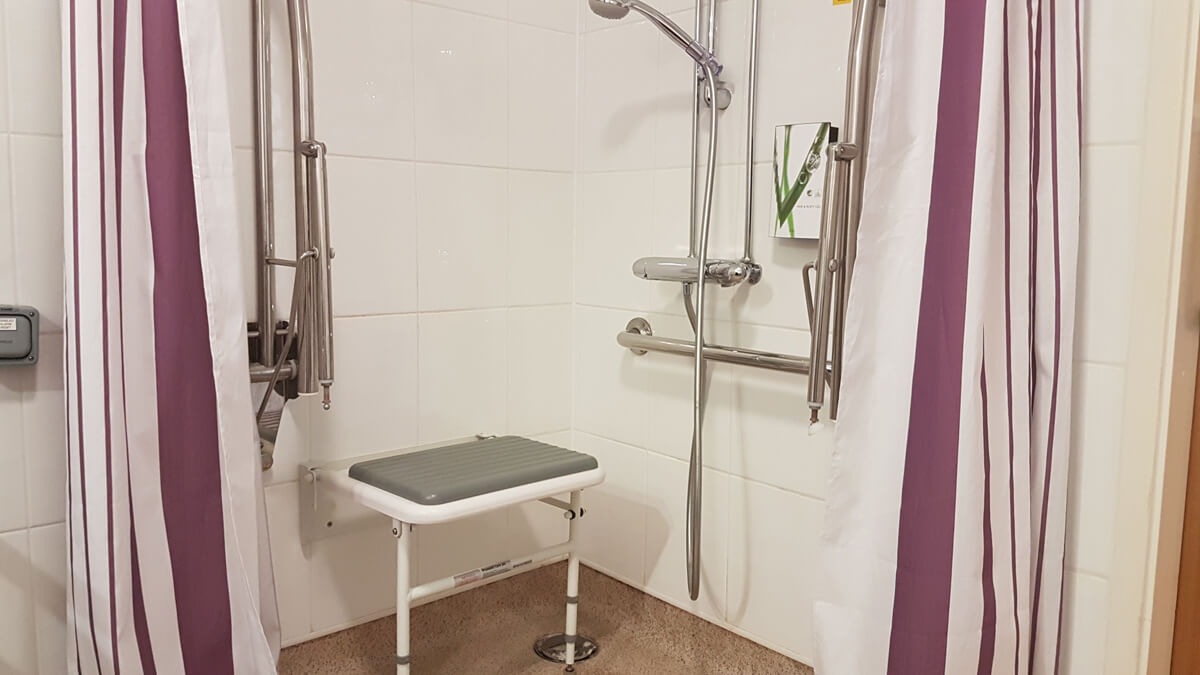 Wall-mounted shower seat in the shower of our accessible room.