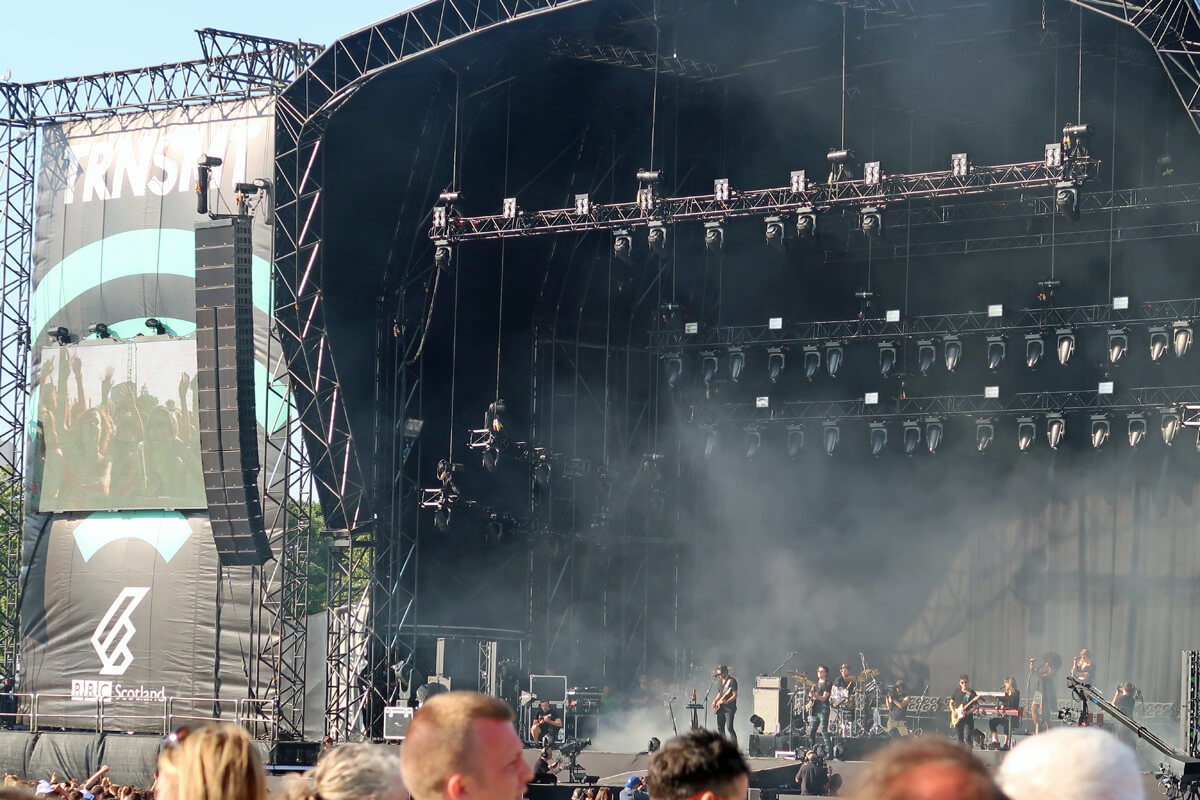James Bay performing on the main stage at TRNSMT festival Glasgow. James is wearing a black t-shirt and tartan trousers.