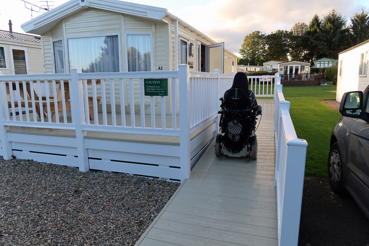 Emma driving her powered wheelchair up the ramp of the wheelchair accessible caravan.