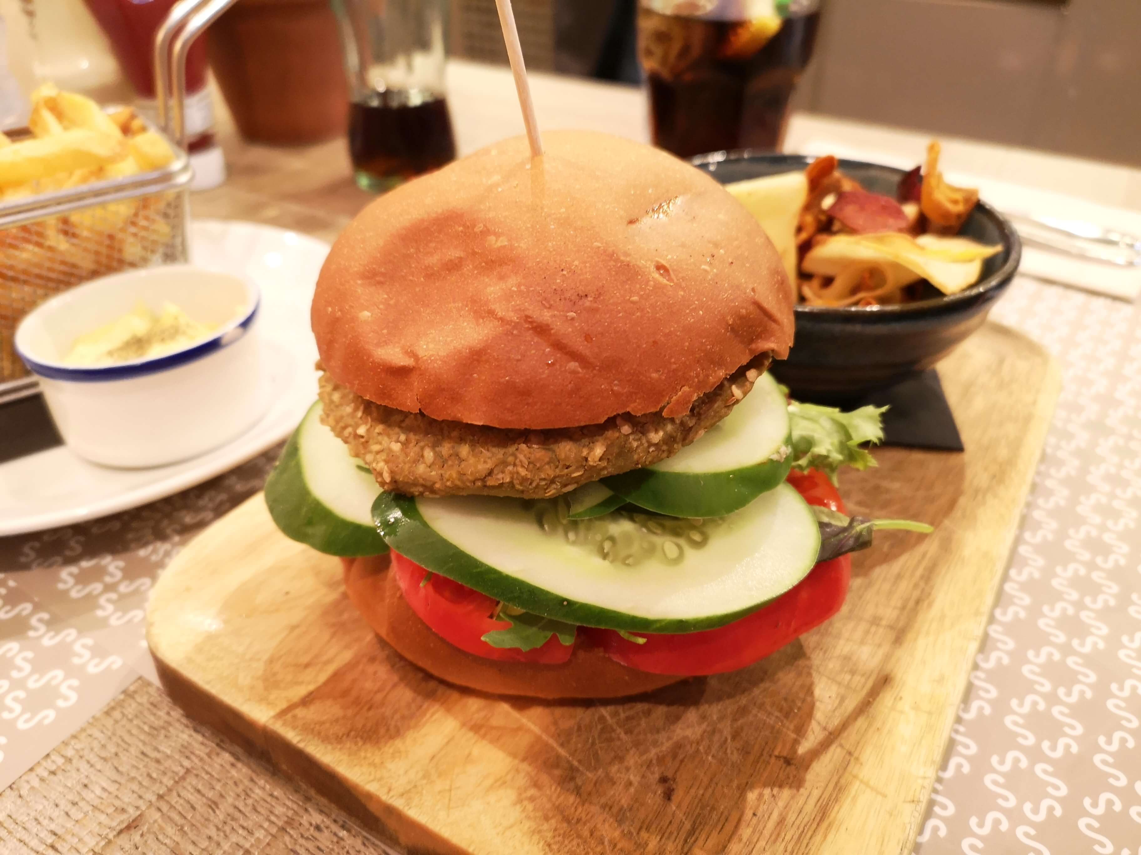 A vegan burger with huge slices of cucumber and tomatoes from Restaurant Singular.