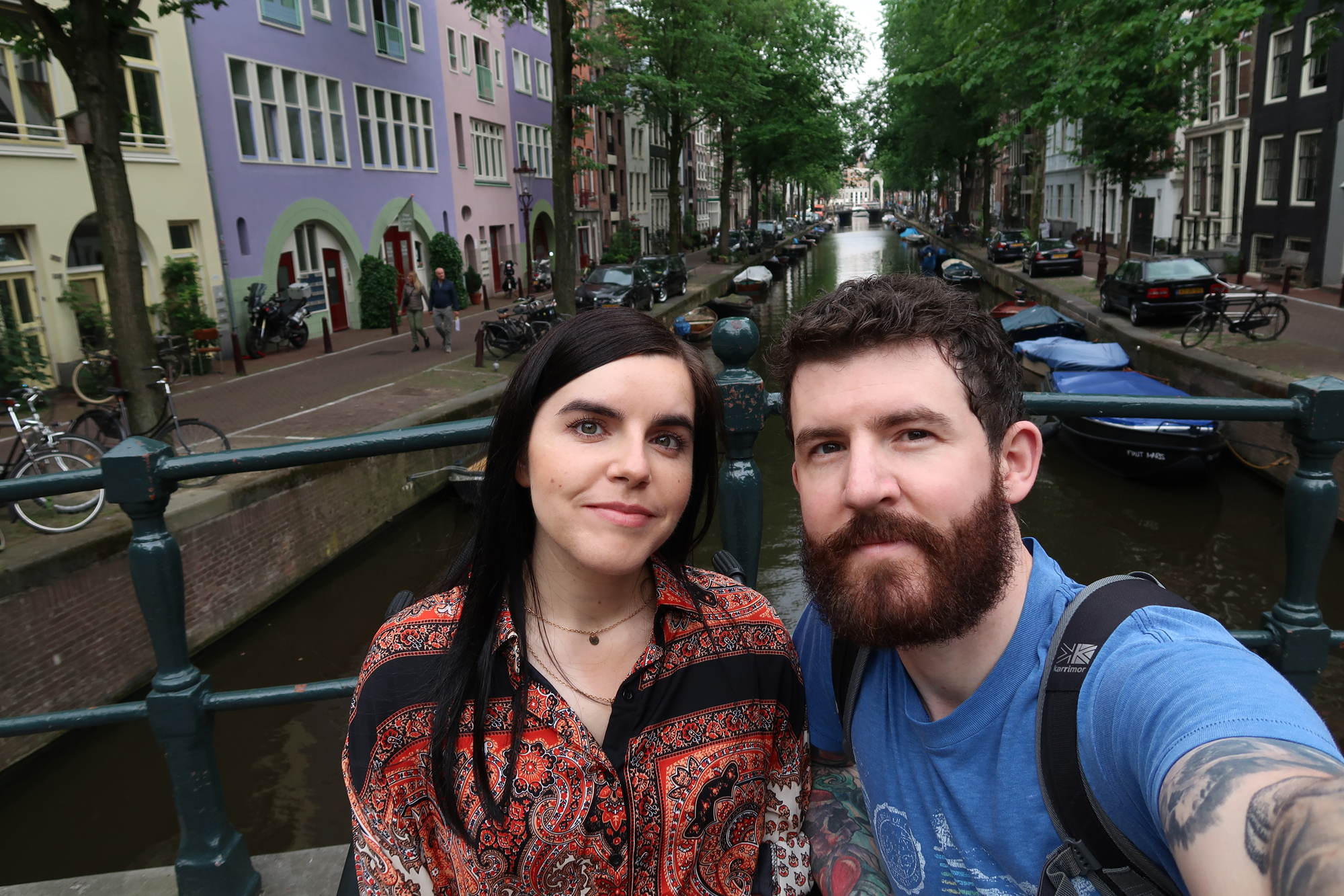 Emma and Allan sitting on a canal bridge in Amsterdam.