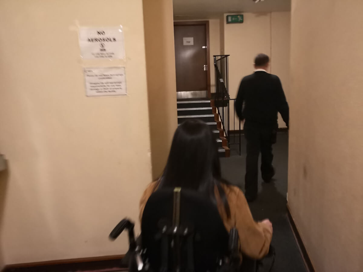 Emma being shown into the theatre through the accessible entrance.