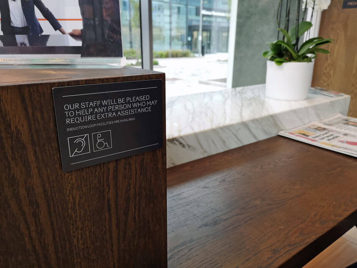 A sign on the reception desk stating if anyone requires extra assistance to please speak to a member of staff.