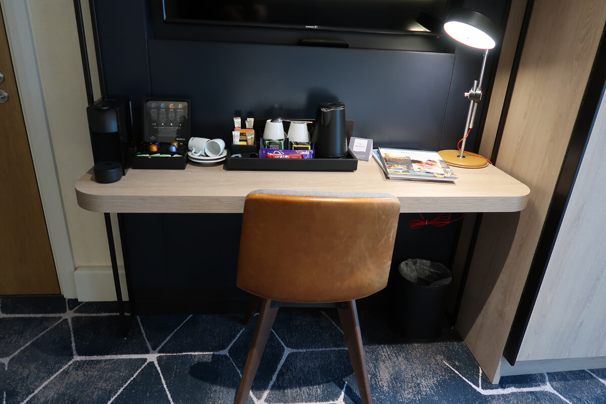 Work desk in our accessible hotel room. A large flatscreen TV is wall mounted above the desk.