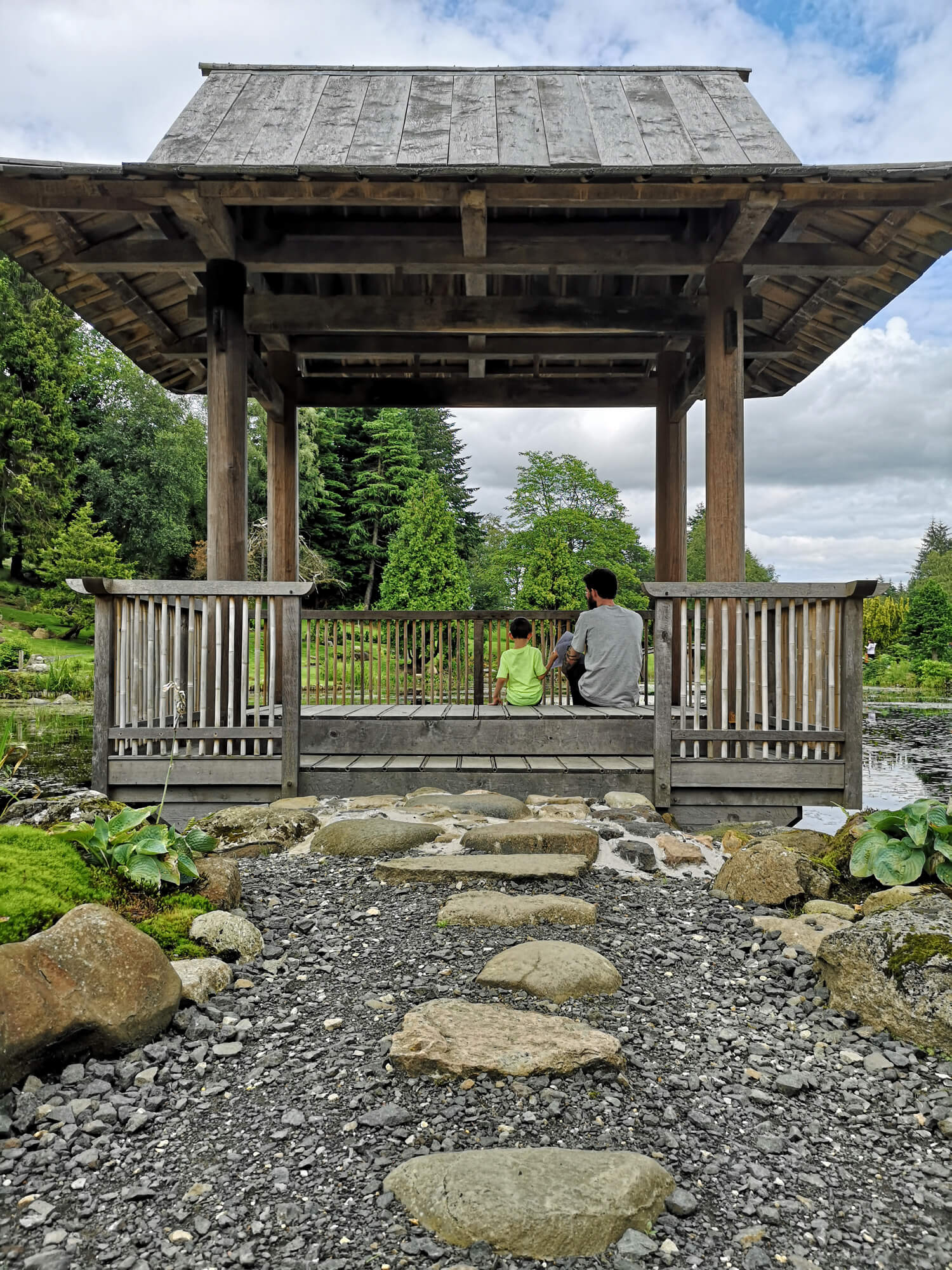 Emma's partner and nephew sitting inside the Japanese House looking across the pond.