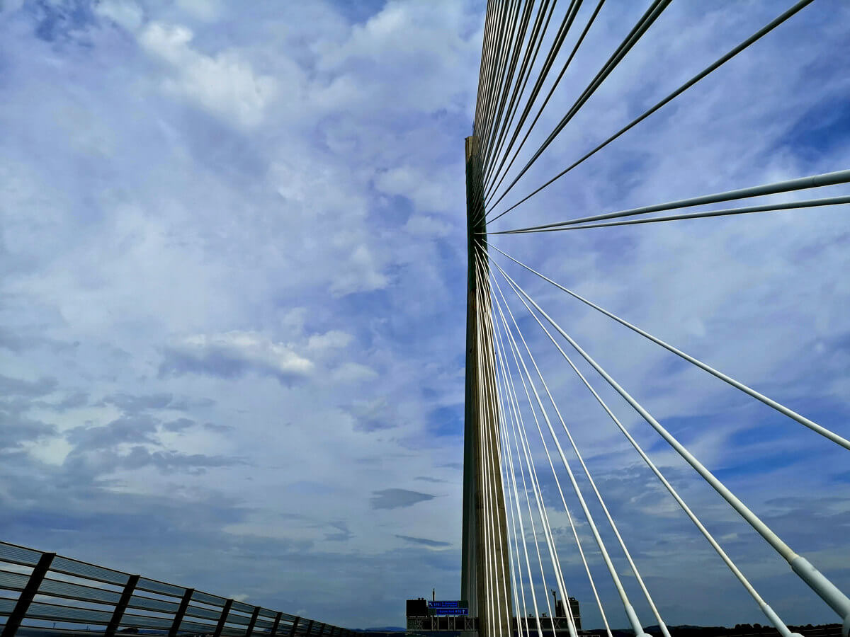 A shot taken from the car driving over the Queensferry Crossing, looking up at the bridge.