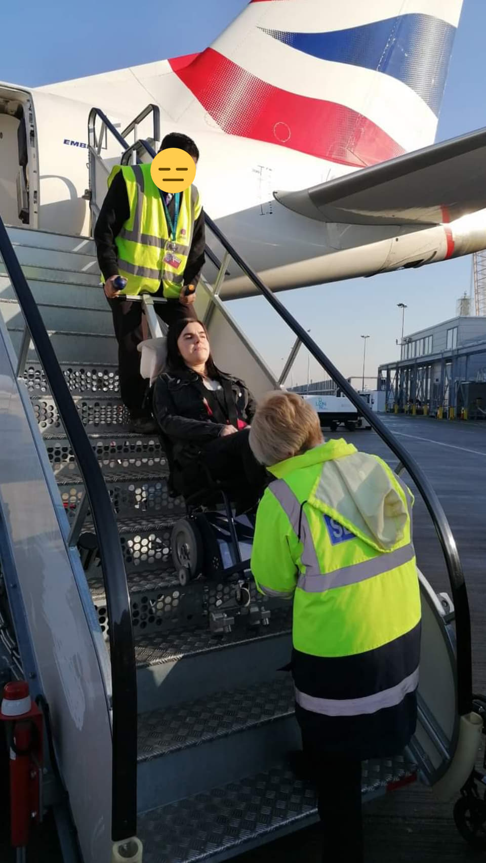 Emma sitting in the stairclimber and being taken down the aircraft stairs with airport staff. This is the view from the bottom of the stairs.