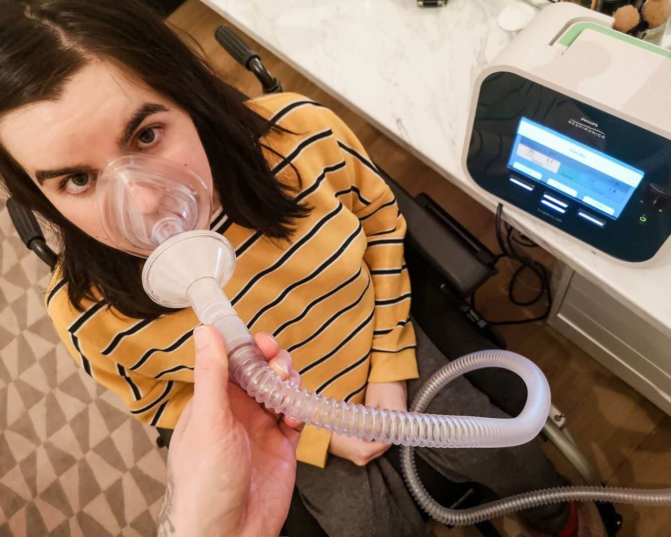 Emma using her cough assist machine