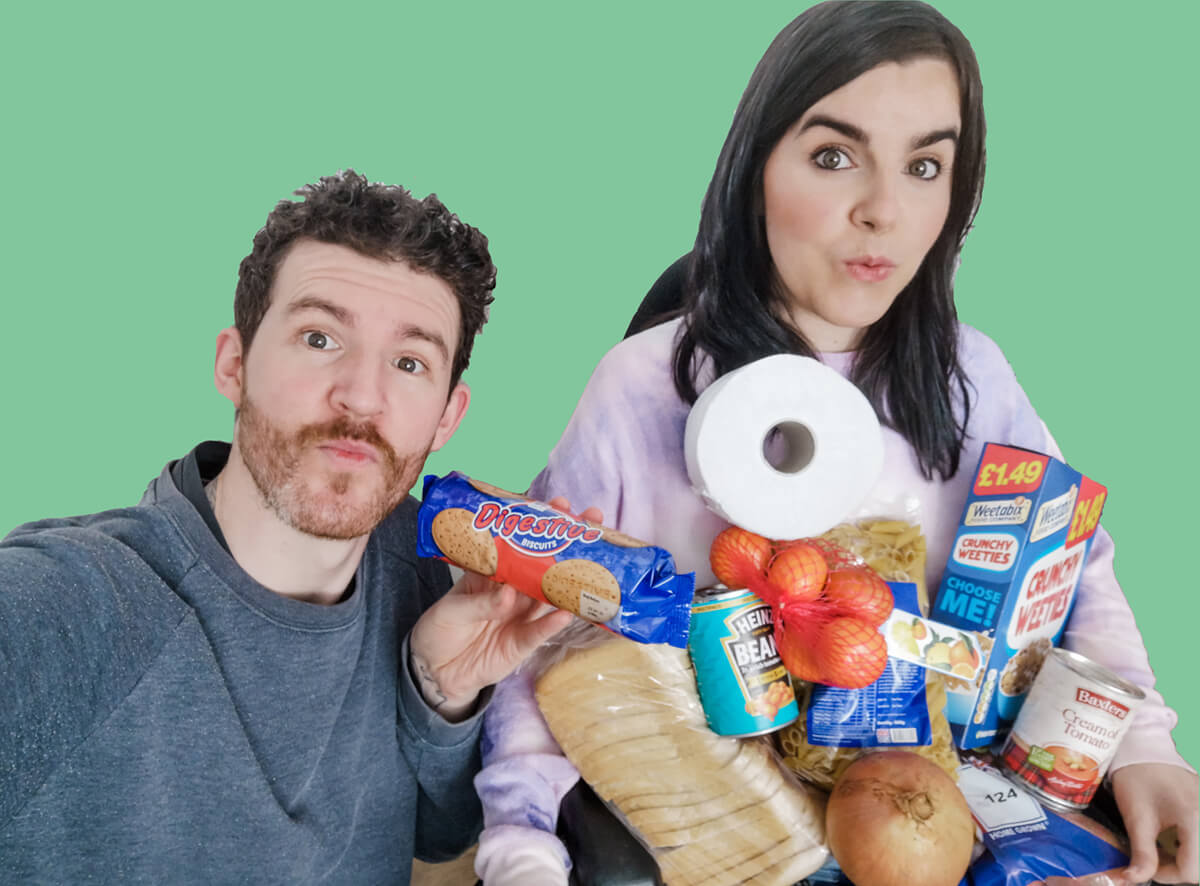 Emma and Allan holding a pile of groceries in their arms.