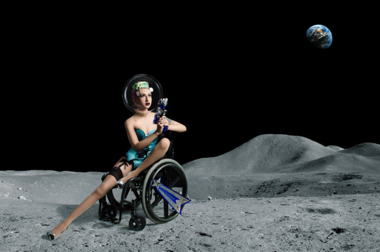 Pansy St Battie sitting in her manual wheelchair during a space themed photoshoot.