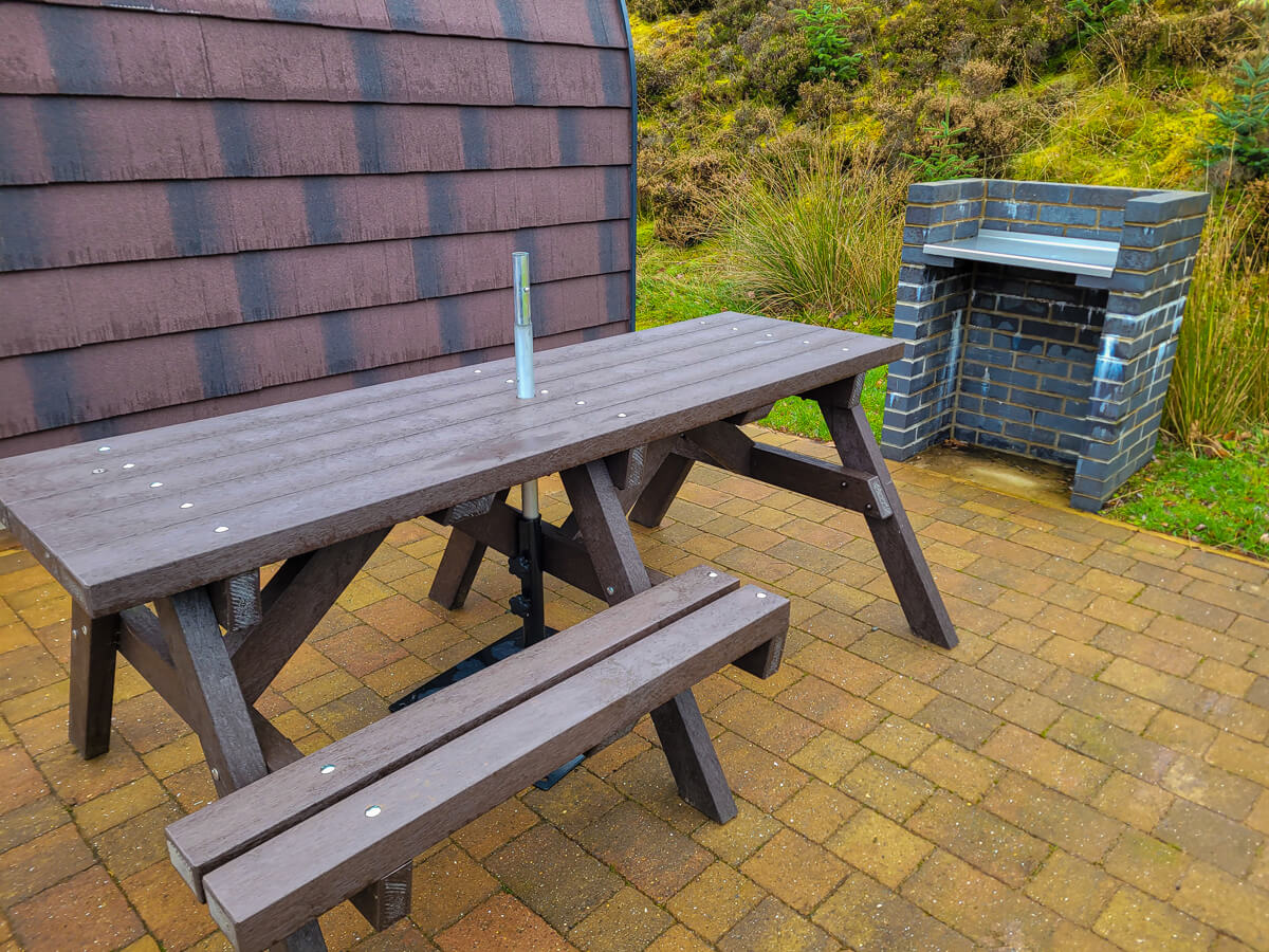 Wheelchair accessible picnic table and a brick BBQ station is next to the glamping pod at Troutbeck Head.