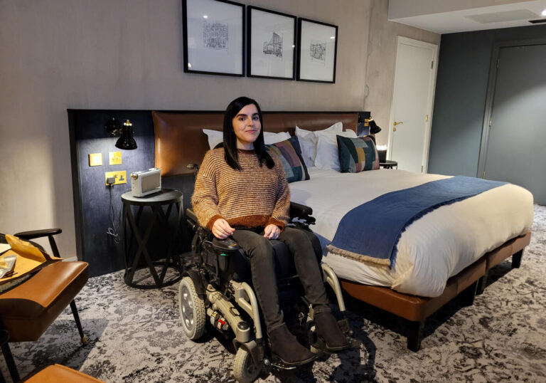 Emma, a wheelchair user sitting in the wheelchair accessible liberty room at Hotel Brooklyn Manchester.