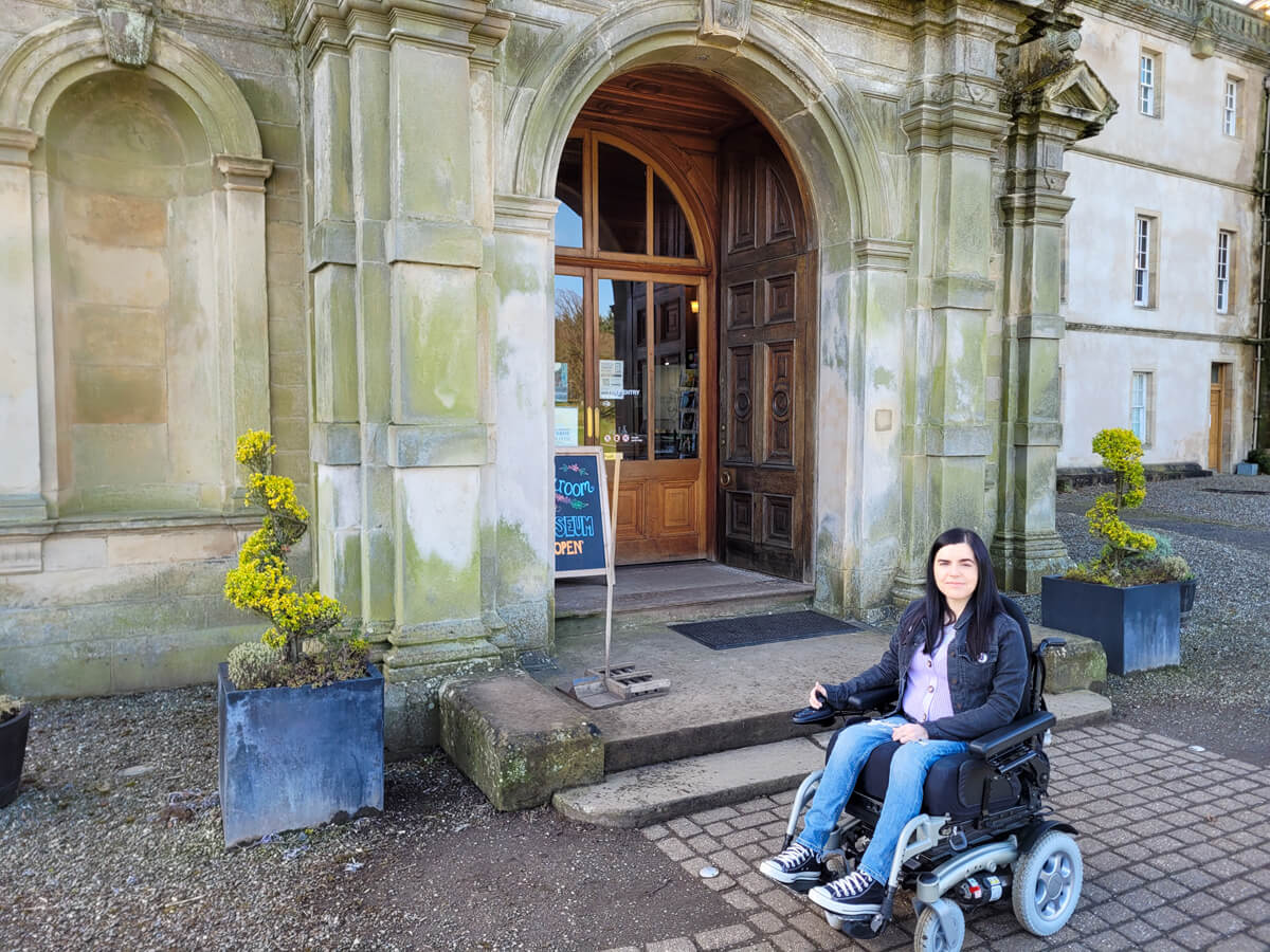 Emma sat in her wheelchair outside at the entrance of Callendar House.