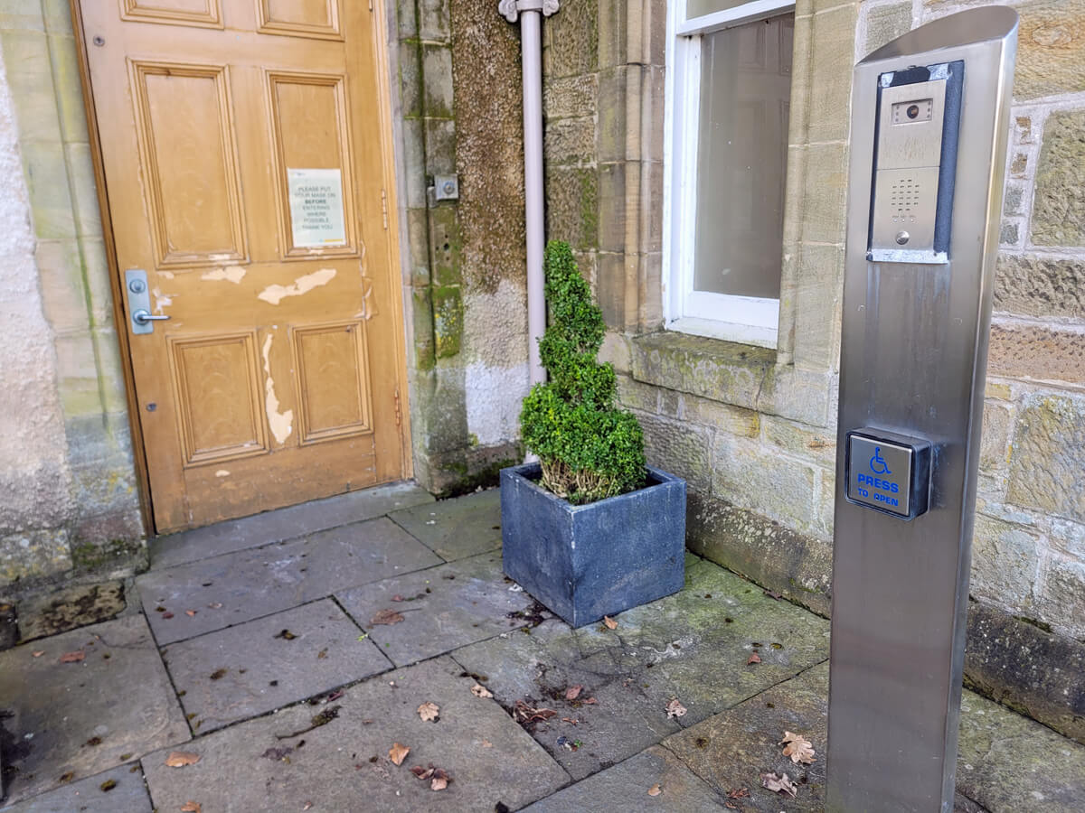 Wheelchair accessible entrance of Callendar House. A 'press to open' button is positioned on the wall.