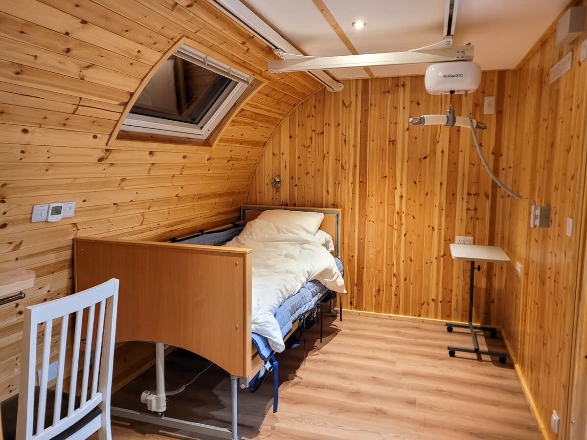 A single profiling bed with overhead ceiling track hoist in the accessible glamping pod at Callander CYP.