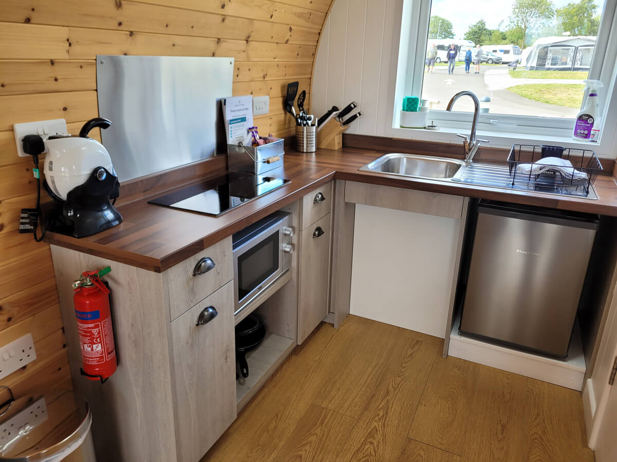 Kitchen with lowered worktops and applicances in the wheelchair accessible glamping pod at Cayton Village.