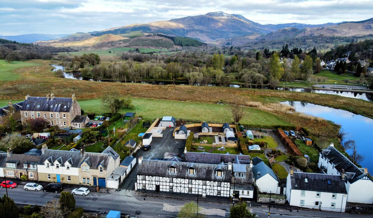 Aerial view of Callander CYP hostel and glamping pods overlooking Ben Ledi and Callander Crags