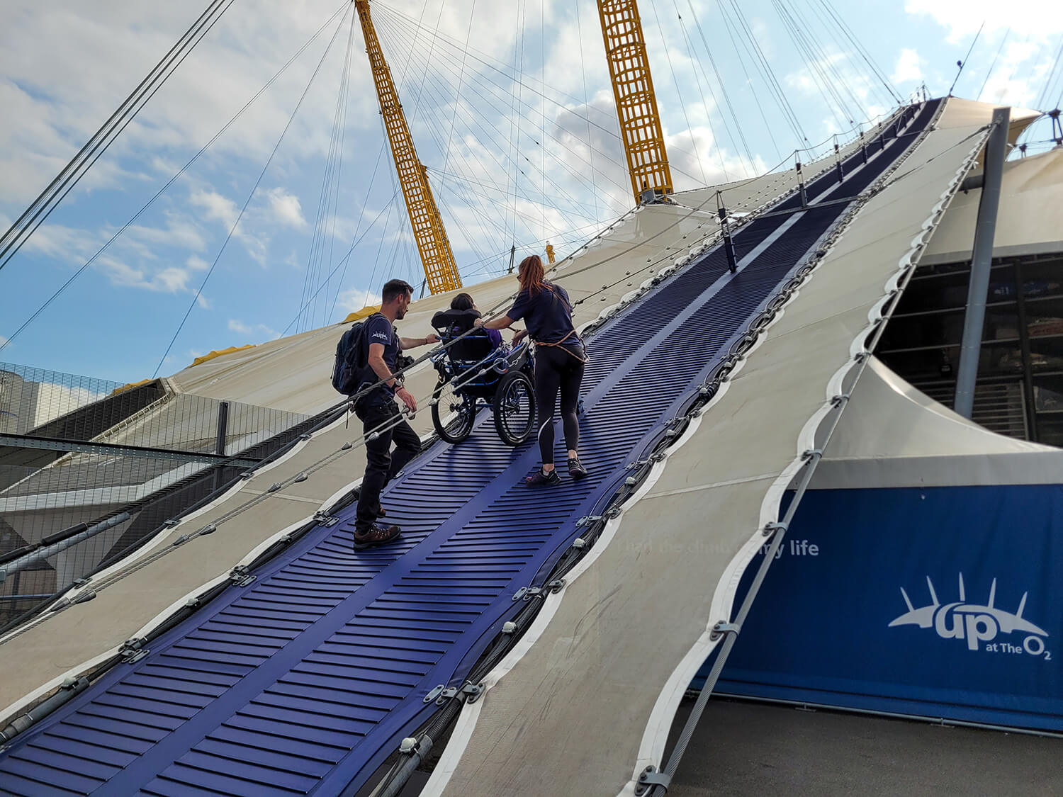Emma and two climb guides pictured on the walkway of the Up at The O2. The are completing the descent.