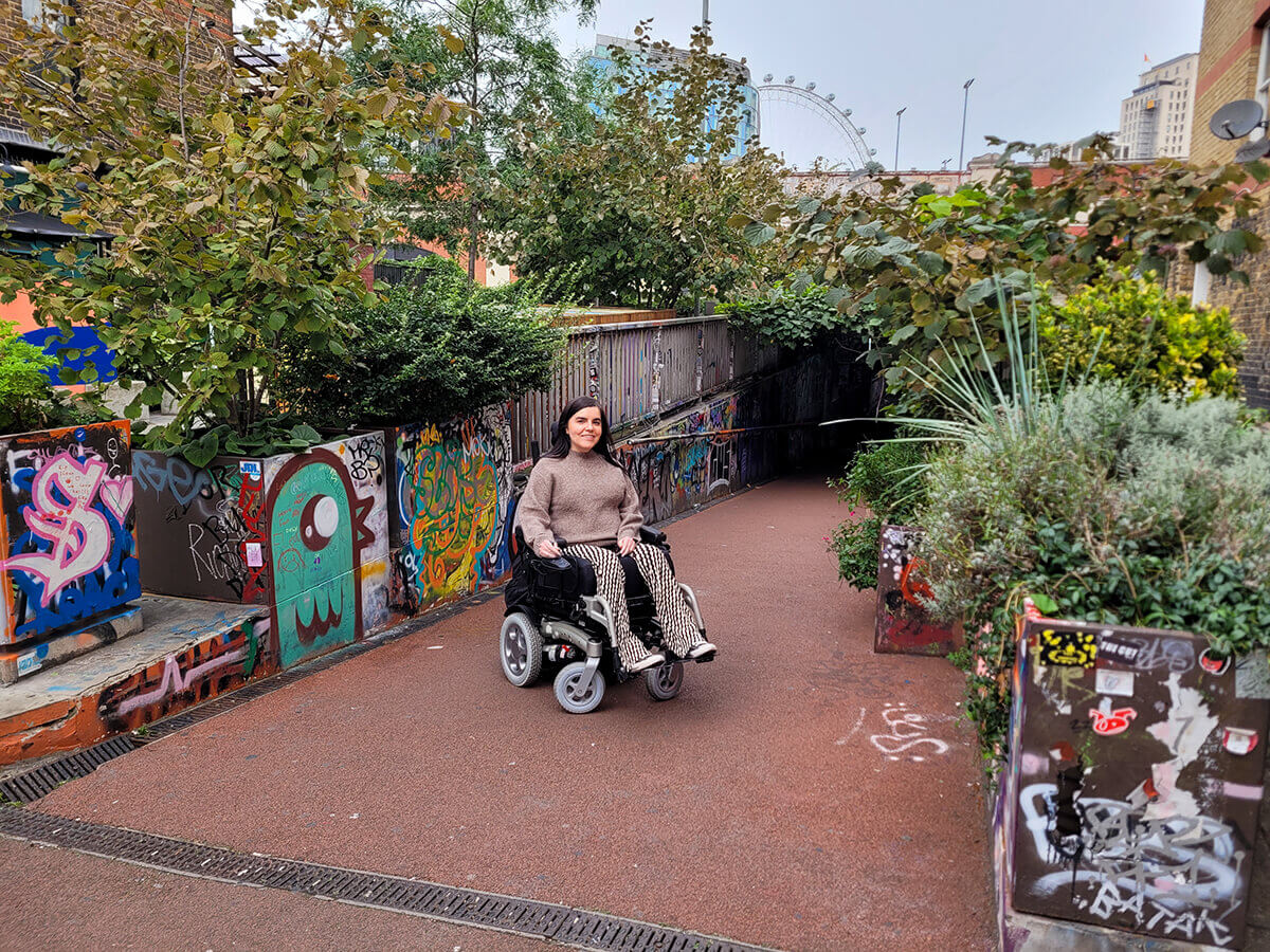 Emma sat in her wheelchair at the entrance to Leake Street Arches - The Graffiti Tunnel