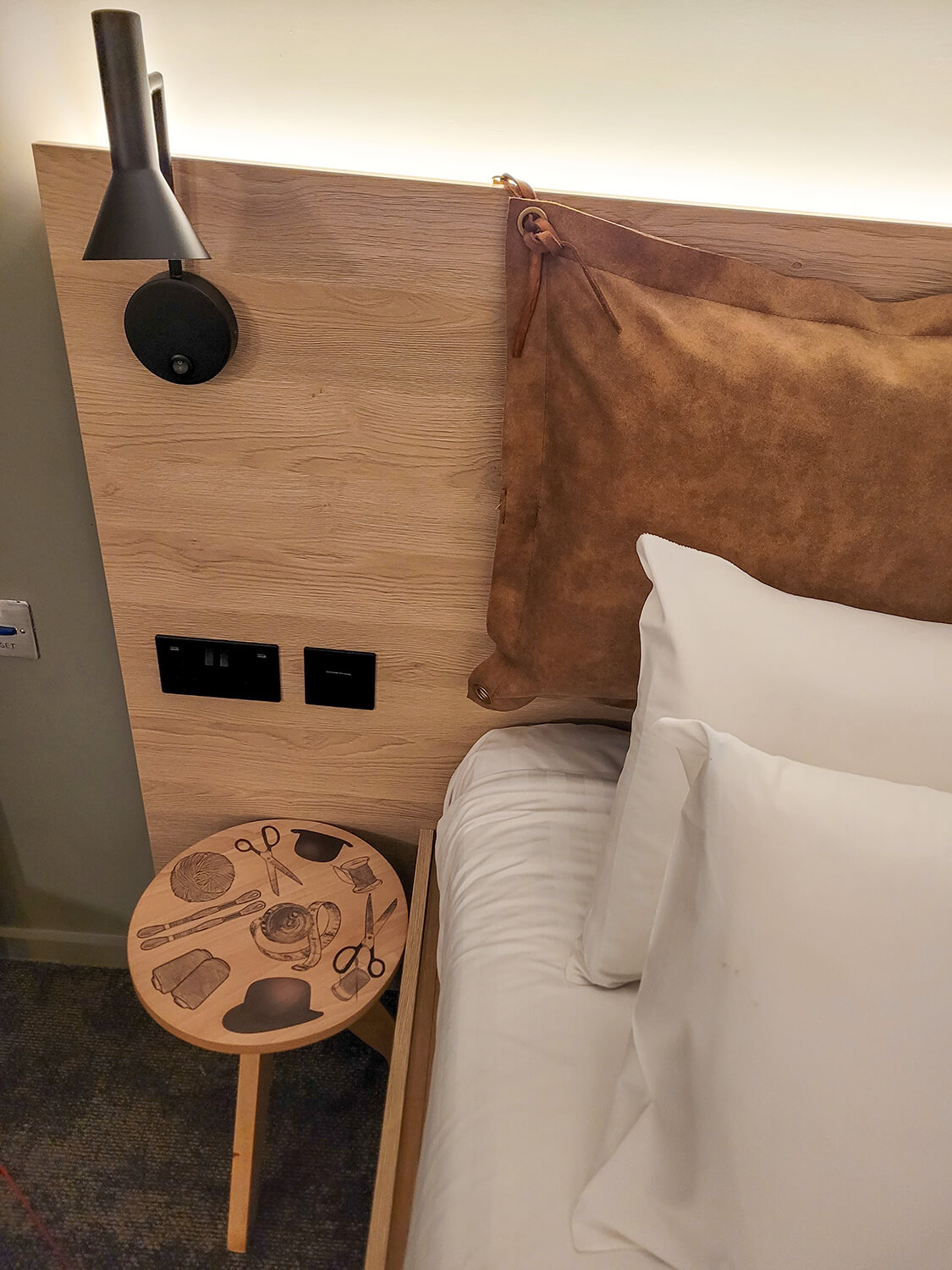 A close up of the bedside table showing the power sockets in the accessible bathroom at the Moxy Manchester City hotel.