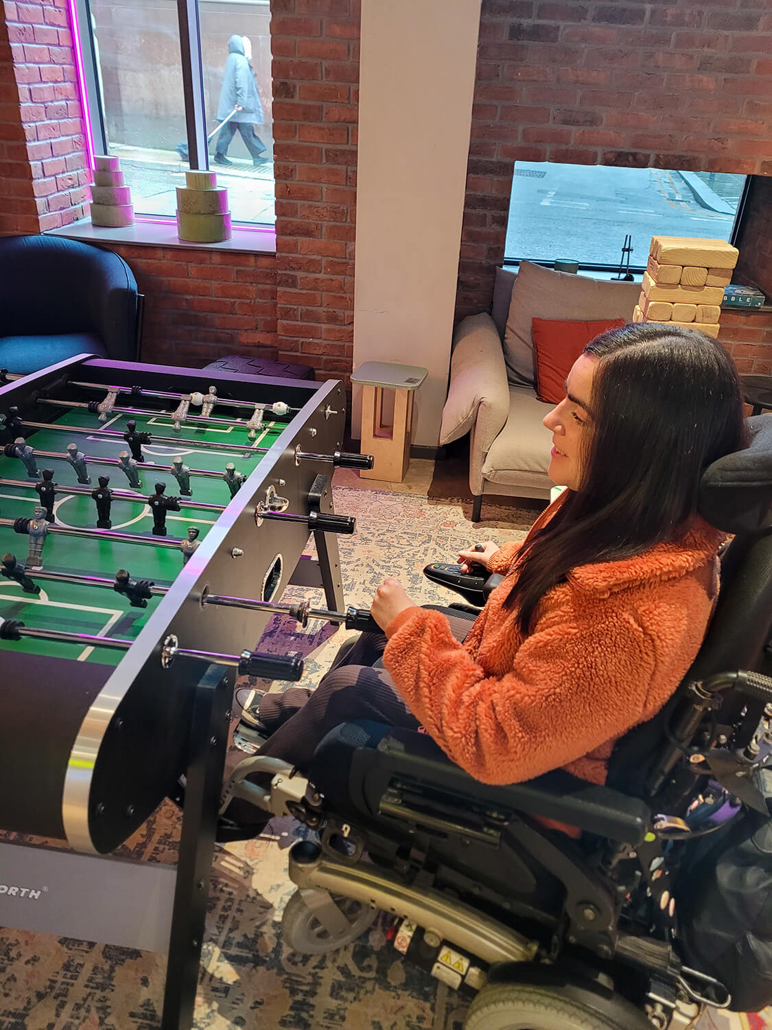 Emma is playing table football at the Moxy Manchester City hotel.