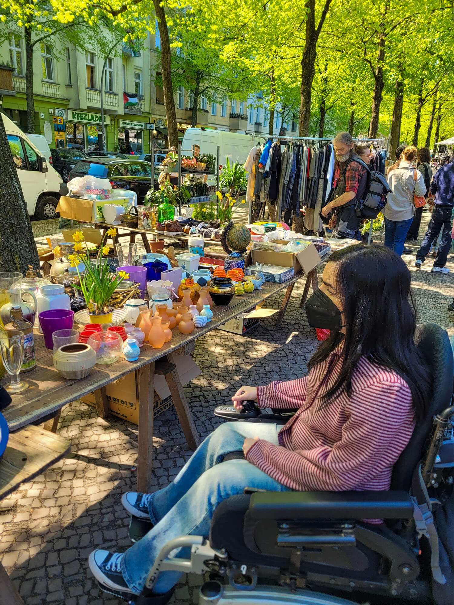 Emma at the Boxhagenerplatz market in Berlin. She is wearing a black face mask.