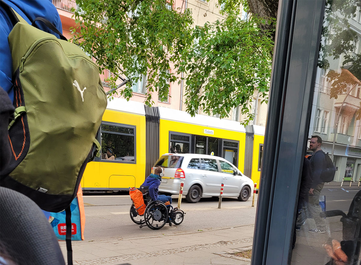 a manual wheelchair user wheeling on the road in Berlin