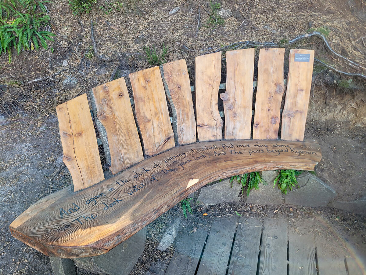 Wooden bench with a quote engraved at the viewing platform at An Lochan Uaine, the Green Loch