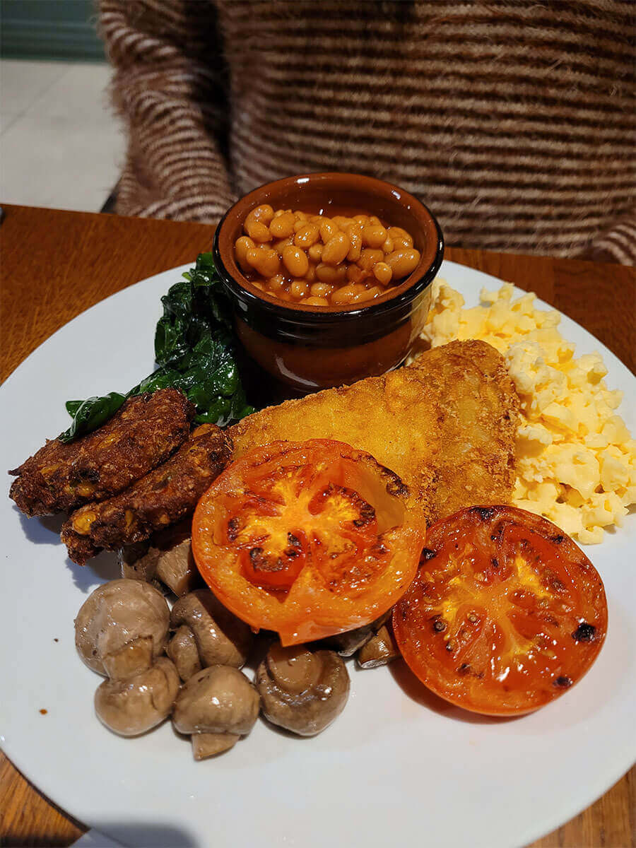 Vegetarian breakfast at Manchester Marriott Victoria & Albert Hotel. The photo shows scrambled eggs, sweetcorn fritters, mushrooms, spinach, baked beans, tomatoes.
