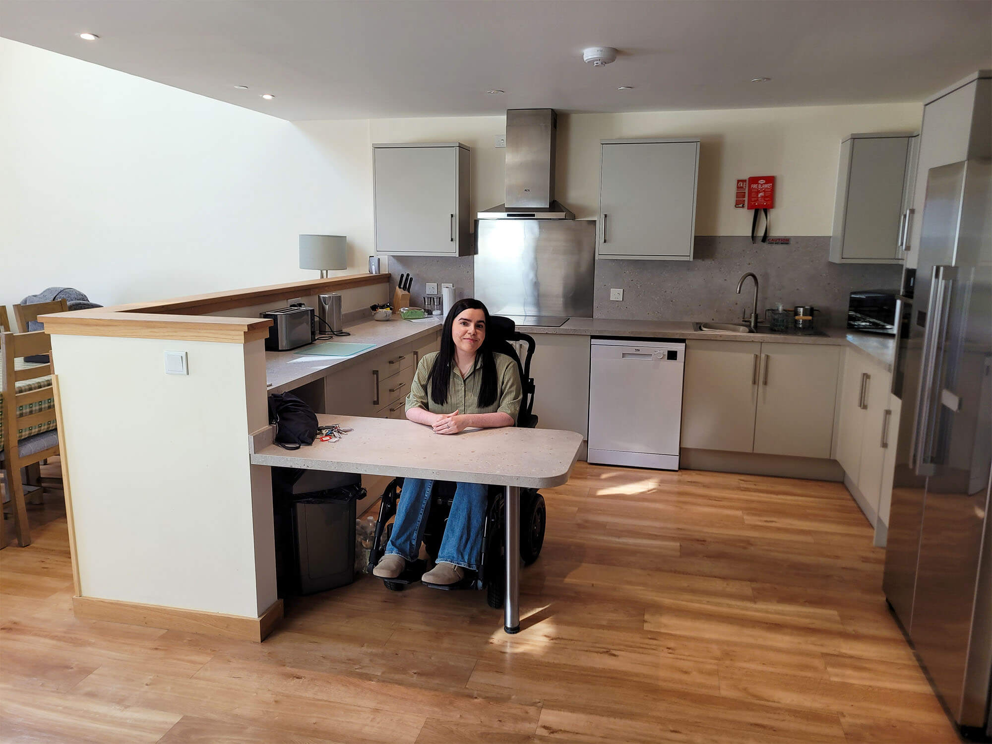 Emma sat at the lowered kitchen worktop in the kitchen of the Largo lodge.