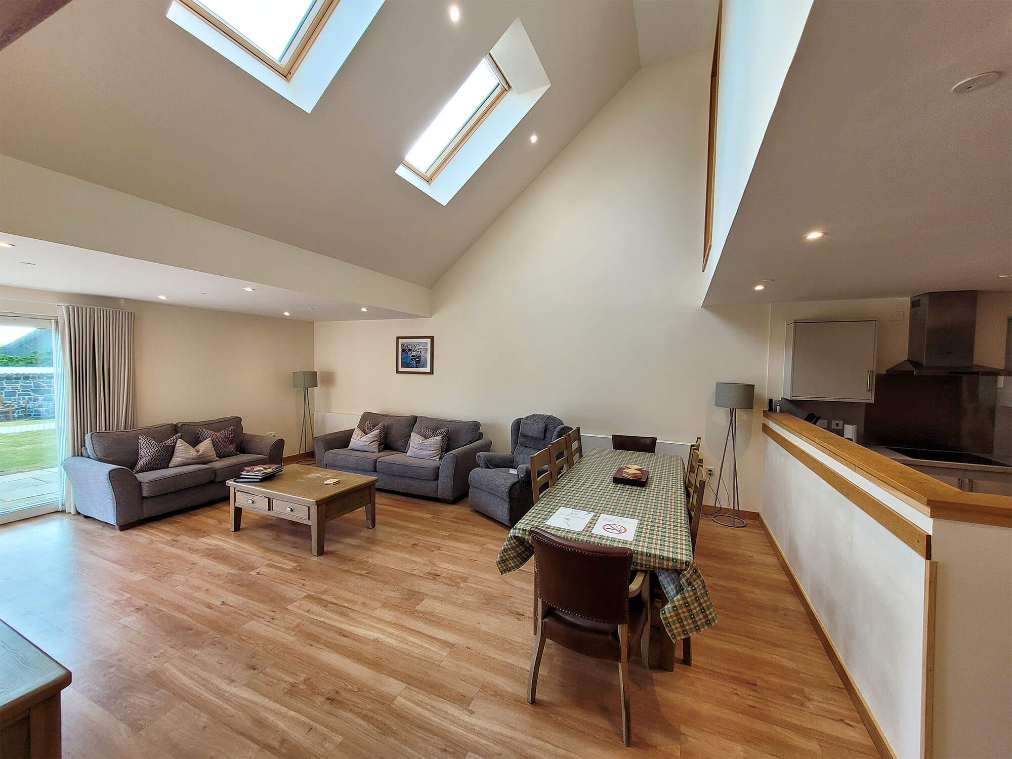 The open plan lounge, dining and kitchen area in the largo lodge at Homelands Trust-Fife with high ceilings and sky light windows.