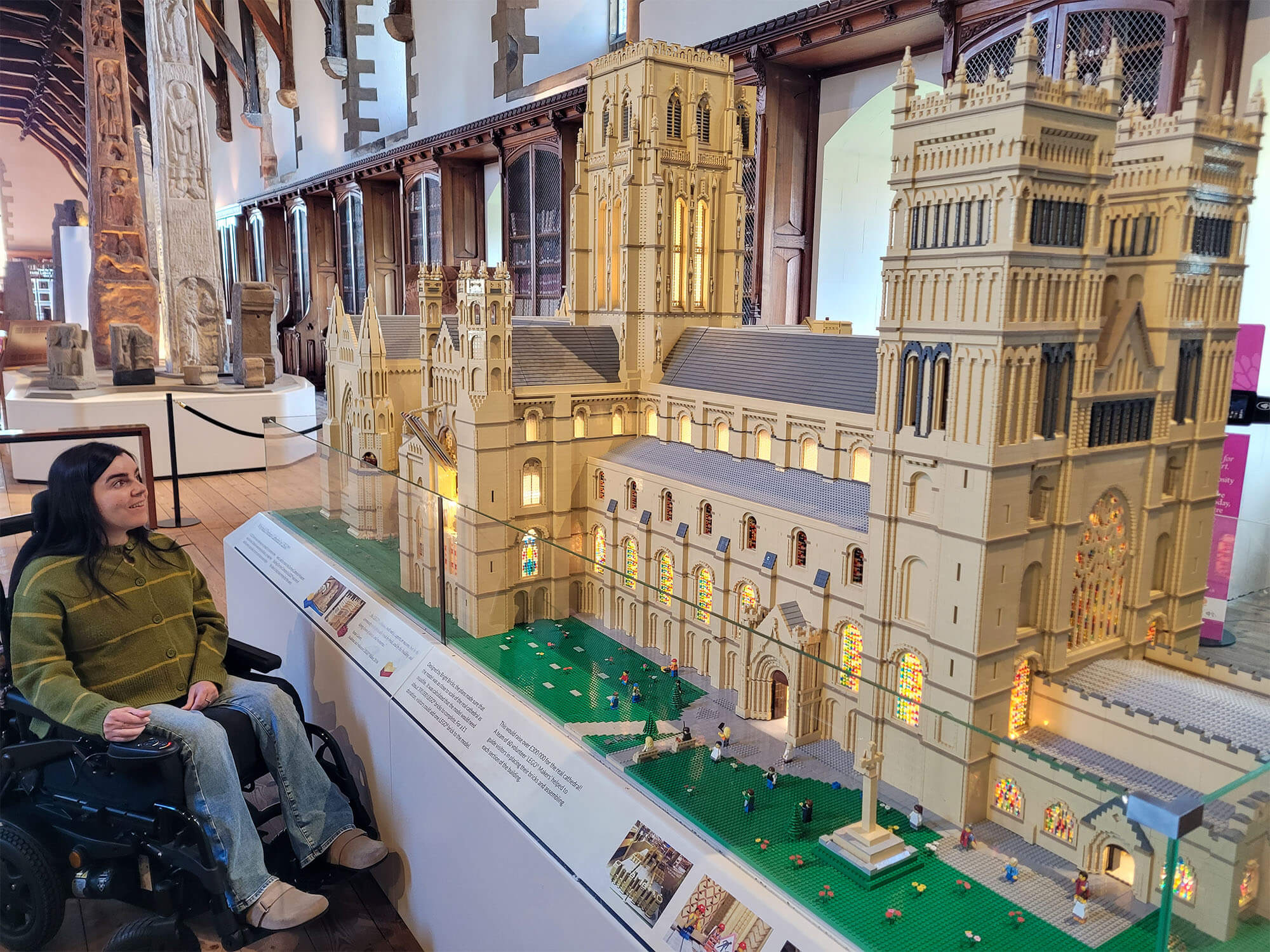 Emma, a wheelchair user, is sitting looking at Durham Cathedral made of LEGO bricks.